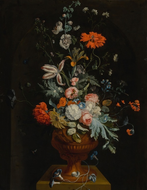 Still life of flowers in a terracotta vase before a stone niche